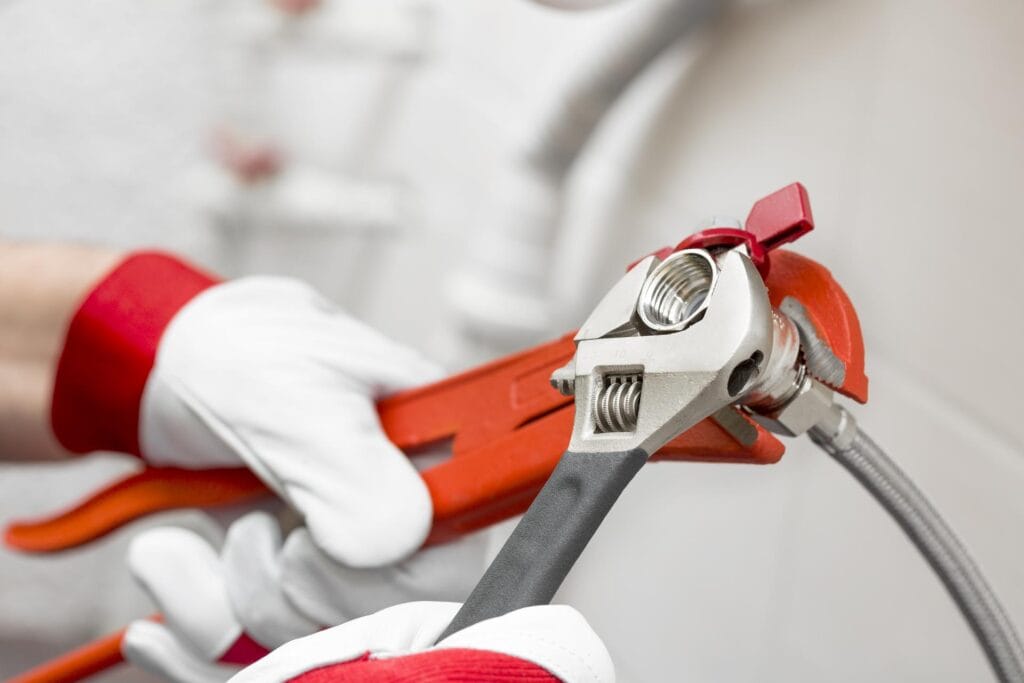 Plumber holding pipe wrenches for an emergency repair in Ocoee