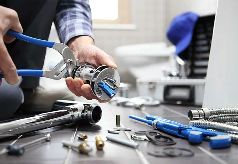 Technician repairing a plumbing fixture with professional tools in Ocoee