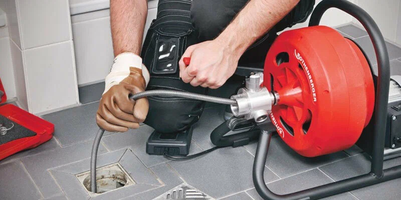 Plumber using a drain-cleaning machine in Ocoee