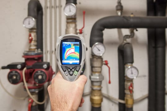 Plumber using a thermal imaging camera to inspect pipes in Ocoee
