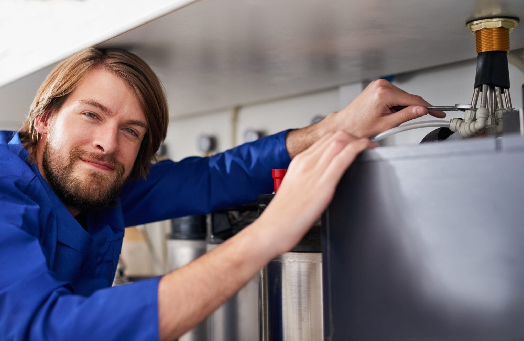 Technician servicing a residential water heater tank in Ocoee